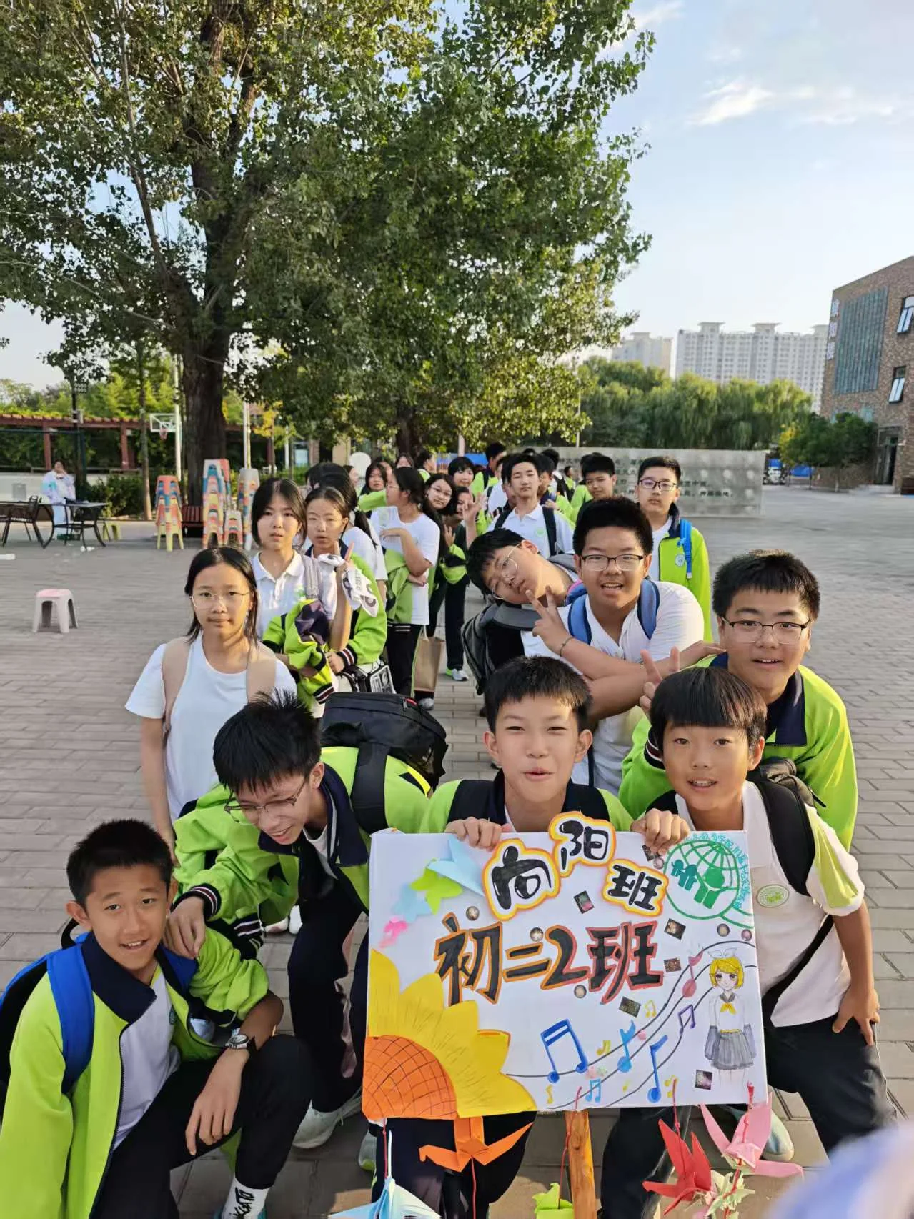 初二2班同学举着向阳班班牌合影